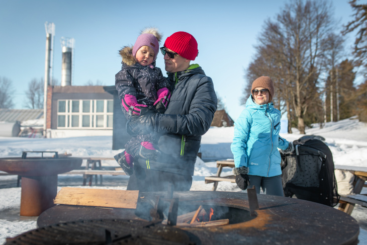Perhe viettämässä talvipäivää Tuusulanjärven rannalla Anttilan tilakeskuksen piknik-paikalla